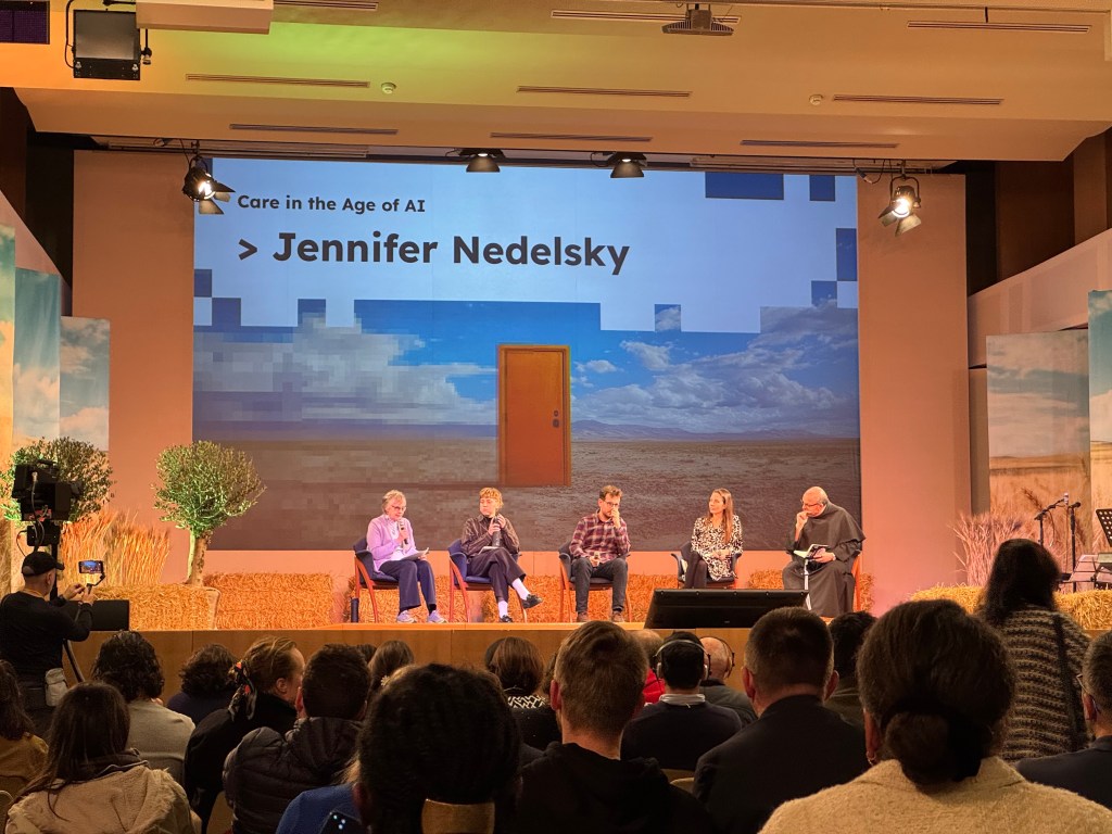 Photo of people on a panel discussion on stage, background reads: "Care in the age of AI: Jennifer Nedelsky"